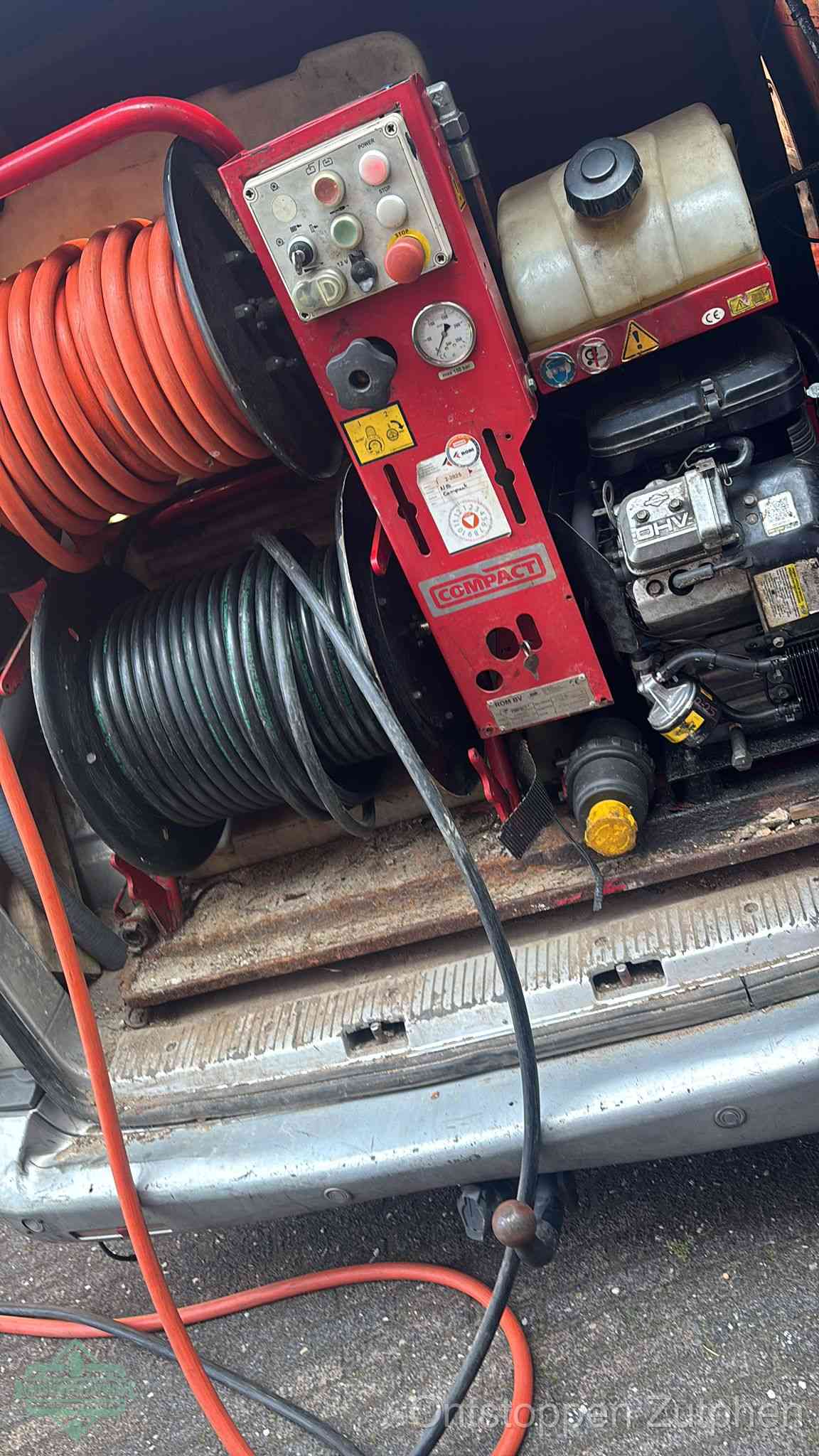 Een rood hogedruk-rioolreinigingstoestel in de laadbak van de bedrijfsbus, apparatuur voor een hardnekkige afvoerverstopping in Zutphen