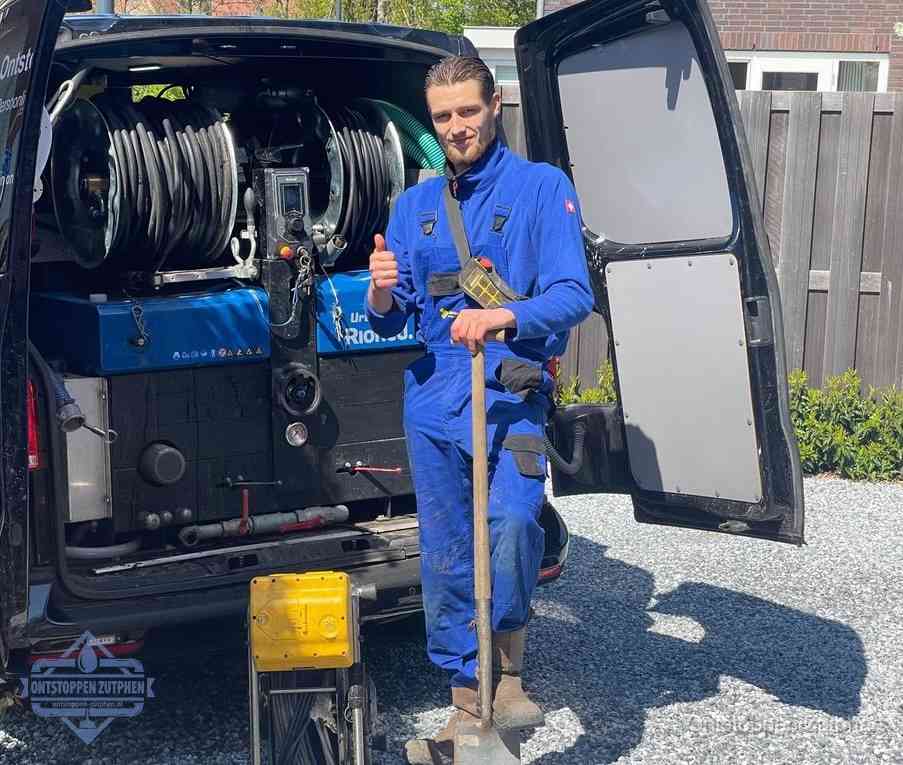 Een monteur bij de werkbus met grote hogedruk-slanghaspels, apparatuur voor hardnekkige afvoerverstoppingen in Zutphen