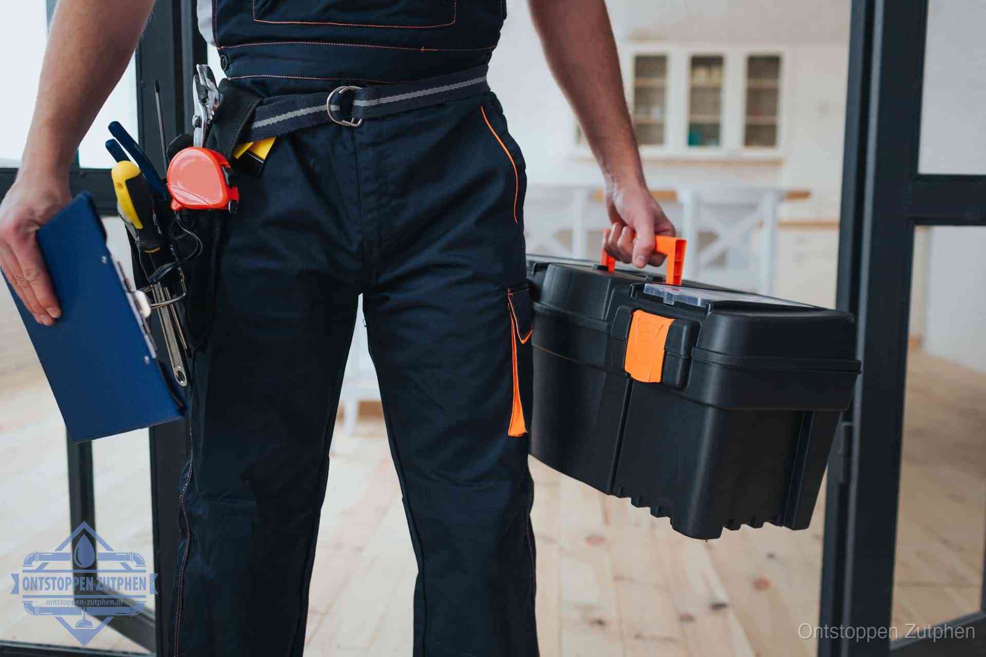 Een monteur met gereedschapsriem en klembord in een keuken, klaar om een transparante prijs voor het gootsteen ontstoppen in Zutphen te geven