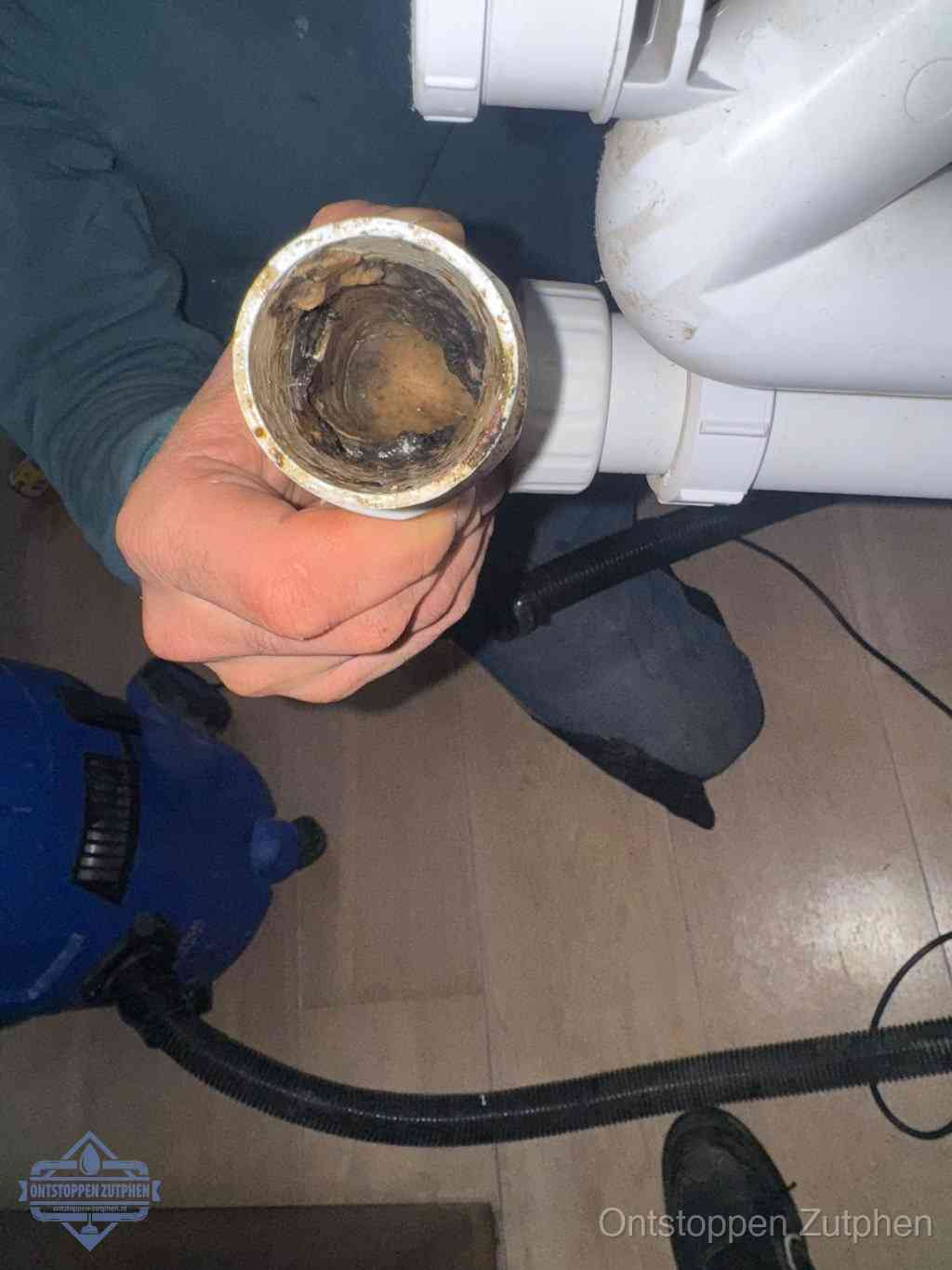 Een losgekoppelde afvoerbuis die van binnen volledig is dichtgeslibd met vet en aanslag, de meest voorkomende oorzaak van een verstopte gootsteen in Zutphen