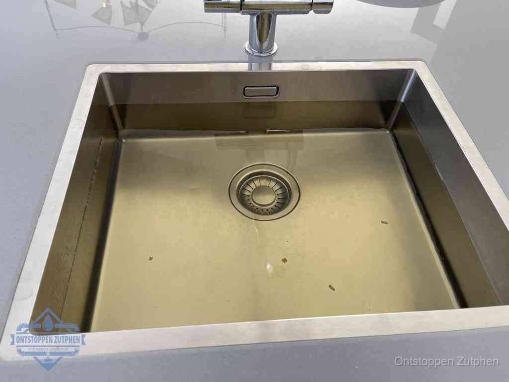 Stilstaand water in een rvs spoelbak dat niet wegloopt, een duidelijk signaal van een gootsteenverstopping in Zutphen