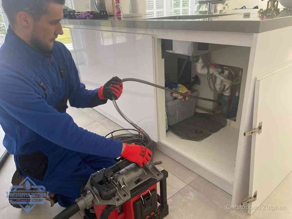 Een monteur reinigt de keukenafvoer grondig met een veermachine om terugkerende gootsteenverstoppingen te voorkomen in Zutphen